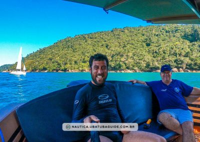 Praia do Cedro ao fundo. No primeiro plano, eu e Pytter sentados na popa durante parada do passeio de barco.