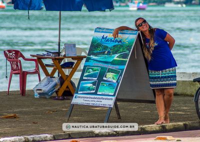 Jennifer apoiada com expressão orgulhosa na placa da Escuna Marina Ubatuba