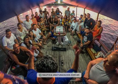 Grupo de pessoas reunidos a bordo da Escuna Marina Ubatuba celebrando aniversário no final do passeio