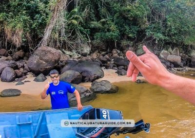 Nilton preparando o embarque com uma de suas lanchas Helohim no rio localizado no extremo direito da Praia do Prumirm