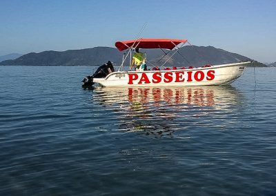 Fábio sozinho na lancha aguardando tripulantes durante passeio cultural conduzido por ele mesmo, caiçara nativo da comunidade da Fortaleza, na região sul de Ubatuba