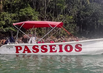 Embarcação utilizada para passeios privativos de lancha em Ubatuba a partir da Praia da Fortaleza ancorada próxima da faixa de areia, onde ocorrem os desembarques de tripulantes