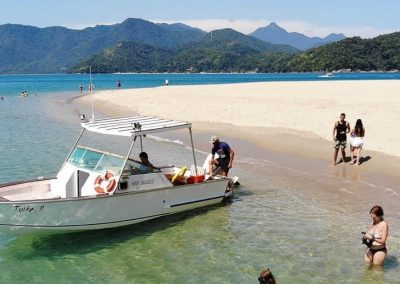Lancha diferenciada da Sol e Sal Turismo Náutico desembarcando nas areias de uma das ilhas paradisíacas de Ubatuba incluídas nos roteiros da operadora