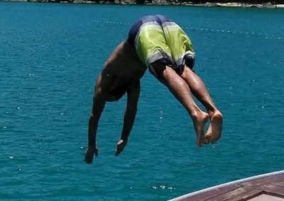 Homem mergulhando da proa. Contudo, a Sol e Sal também oferece passeios de mergulho em Ubatuba