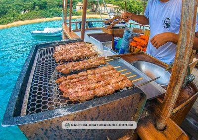 Churrasco sendo preparado, um dos diferenciais desse passeio de escuna em Ubatuba